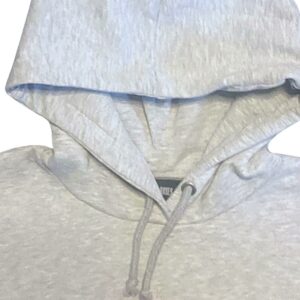 Détail de la capuche doublée coton avec œillets métalliques et lien de serrage.